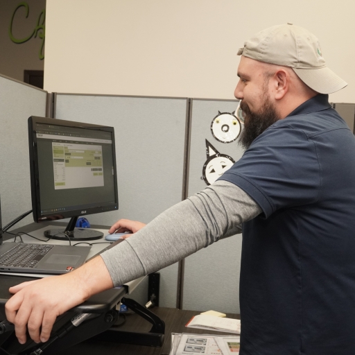 A SignCraft Solutions staff member working at a computer in their office.